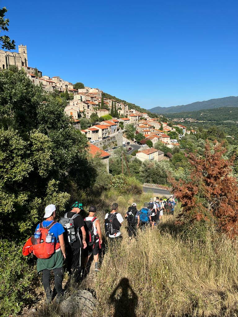 trekking-reosch-2022-pyrenaen-schueler-in-kolonne-bei-dorf.jpg